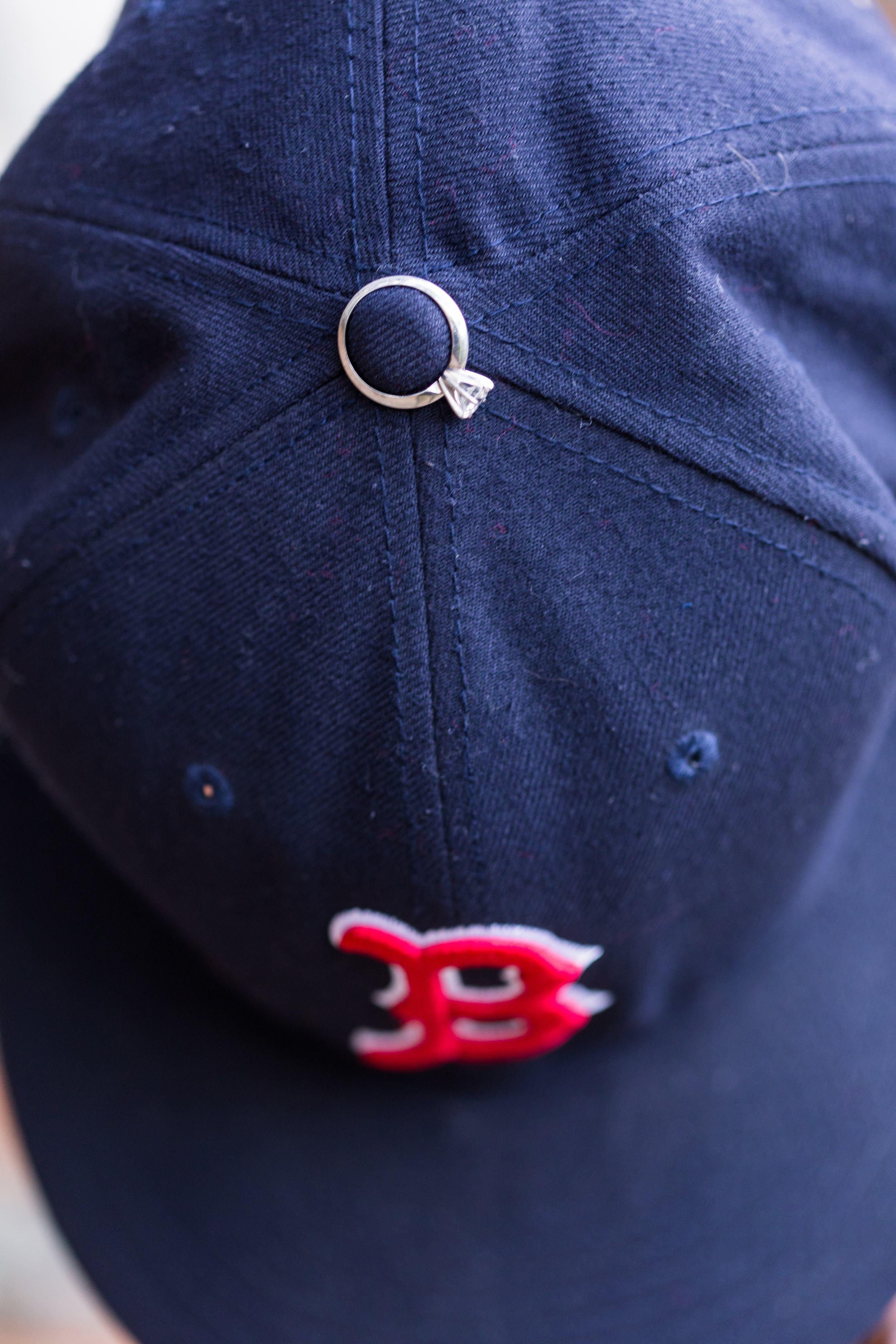 engagement ring on boston red sox baseball hat at middlesex fells