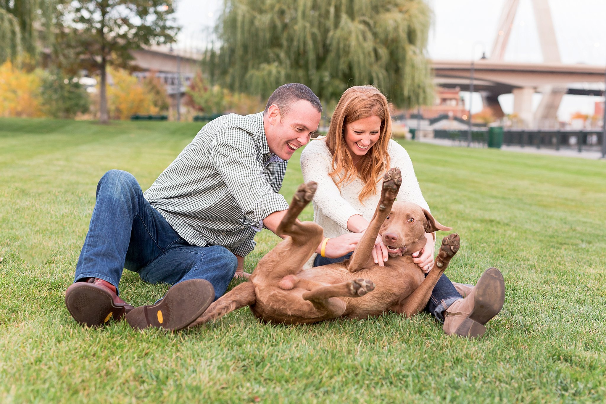 Couple playing with their chesapeake bay retriever