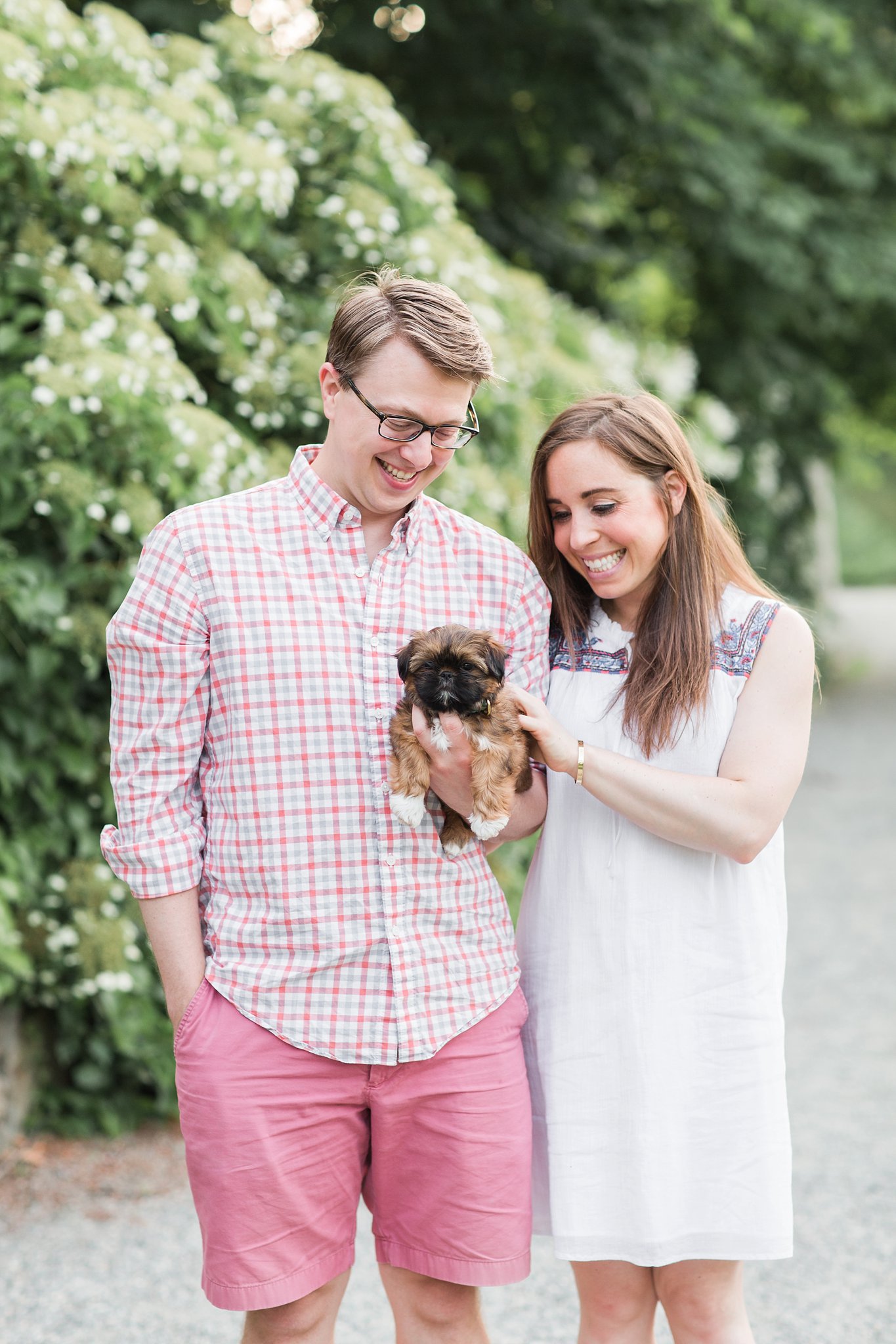 couple holding their shih tzu puppy in the Arnold Arboretum in Jamaica Pond, MA