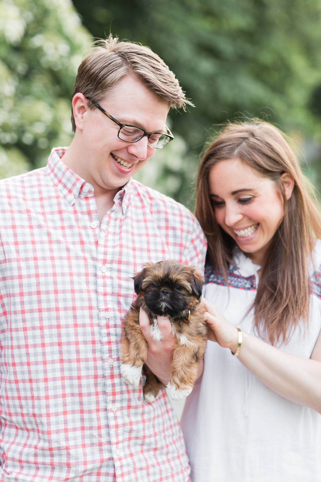 couple holding their shih tzu puppy in the Arnold Arboretum in Jamaica Pond, MA