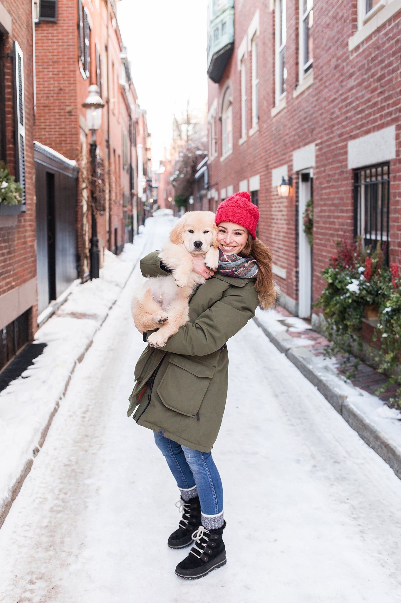 woman holding a golden retriever puppy in the streets of Beacon Hill, Boston