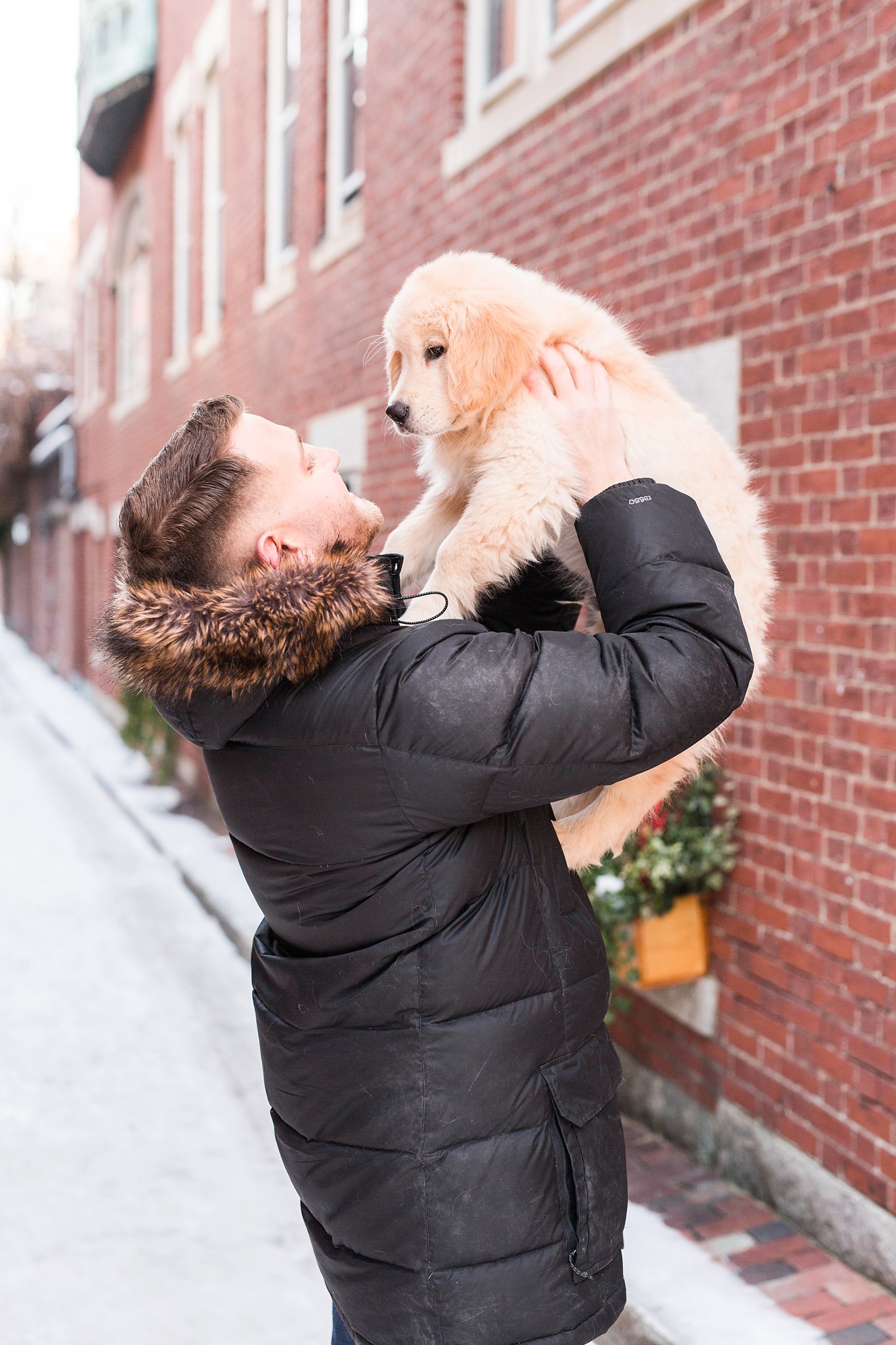 man holding a golden retriever puppy in the streets of Beacon Hill, Boston