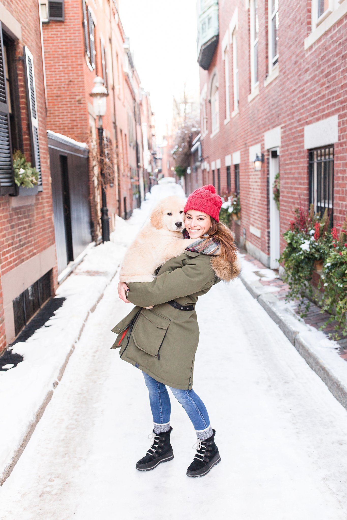 woman holding a golden retriever puppy in the streets of Beacon Hill, Boston