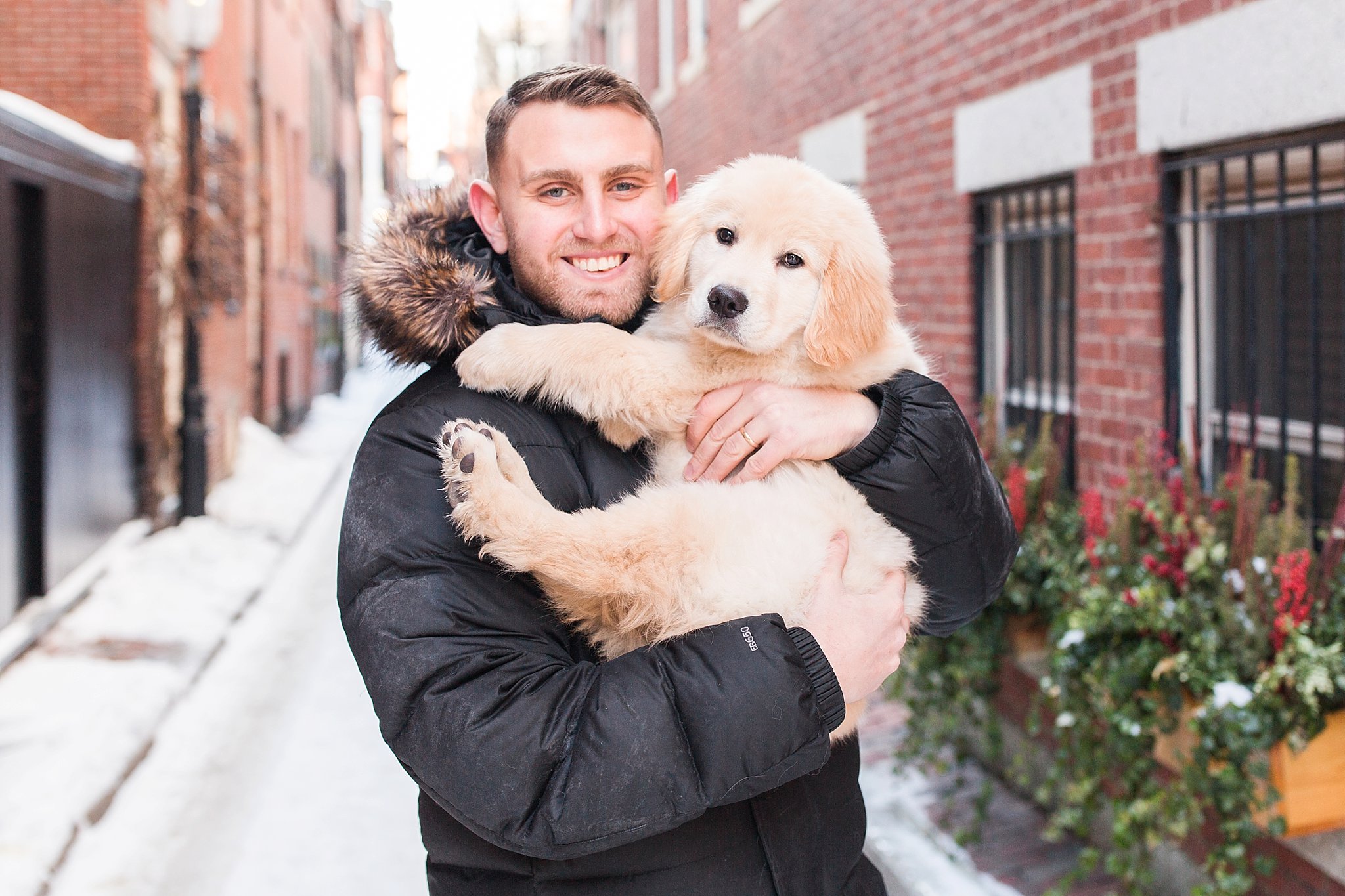 man holding a golden retriever puppy in the streets of Beacon Hill, Boston