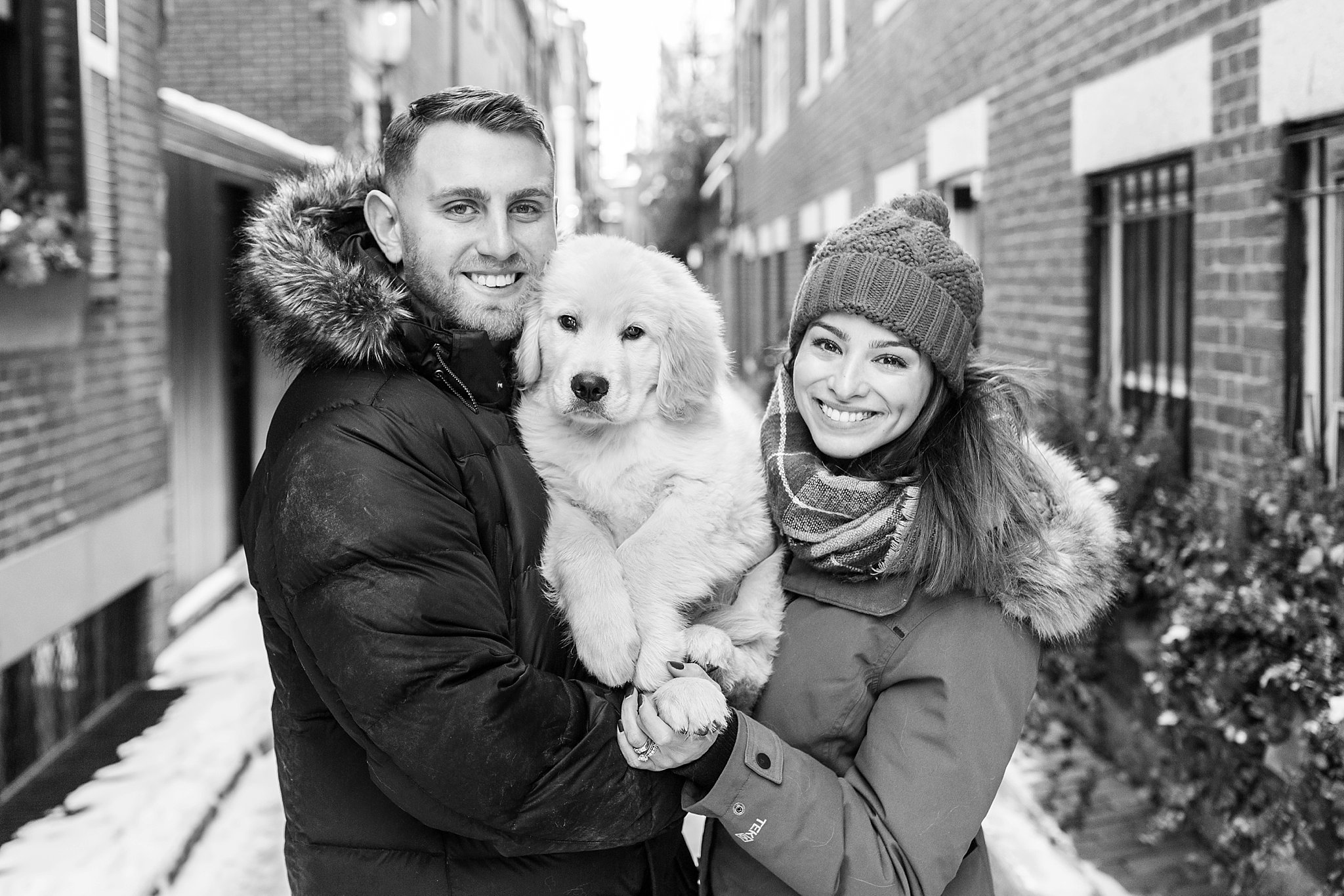 couple holding a golden retriever puppy in the streets of Beacon Hill, Boston