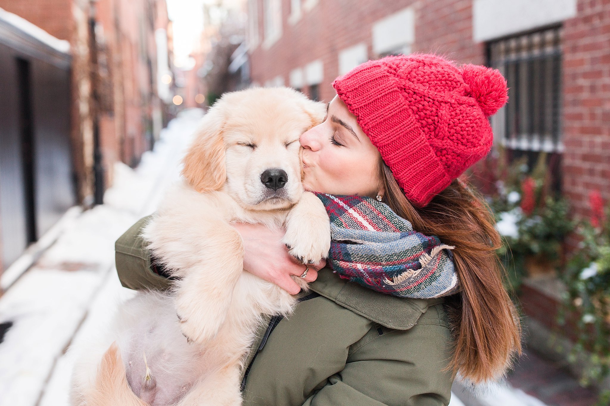 woman kissing her golden retriever puppy in the streets of Beacon Hill, Boston
