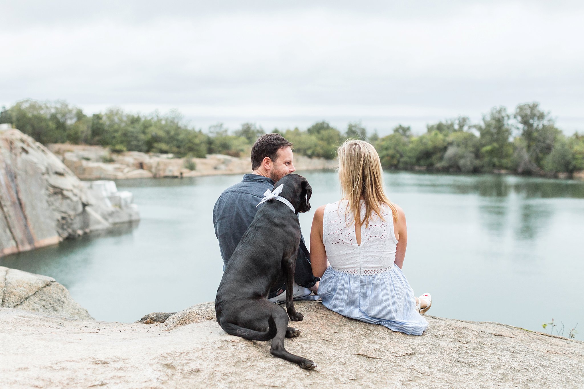 couple and their dog sitting on ledge at halibut point state park