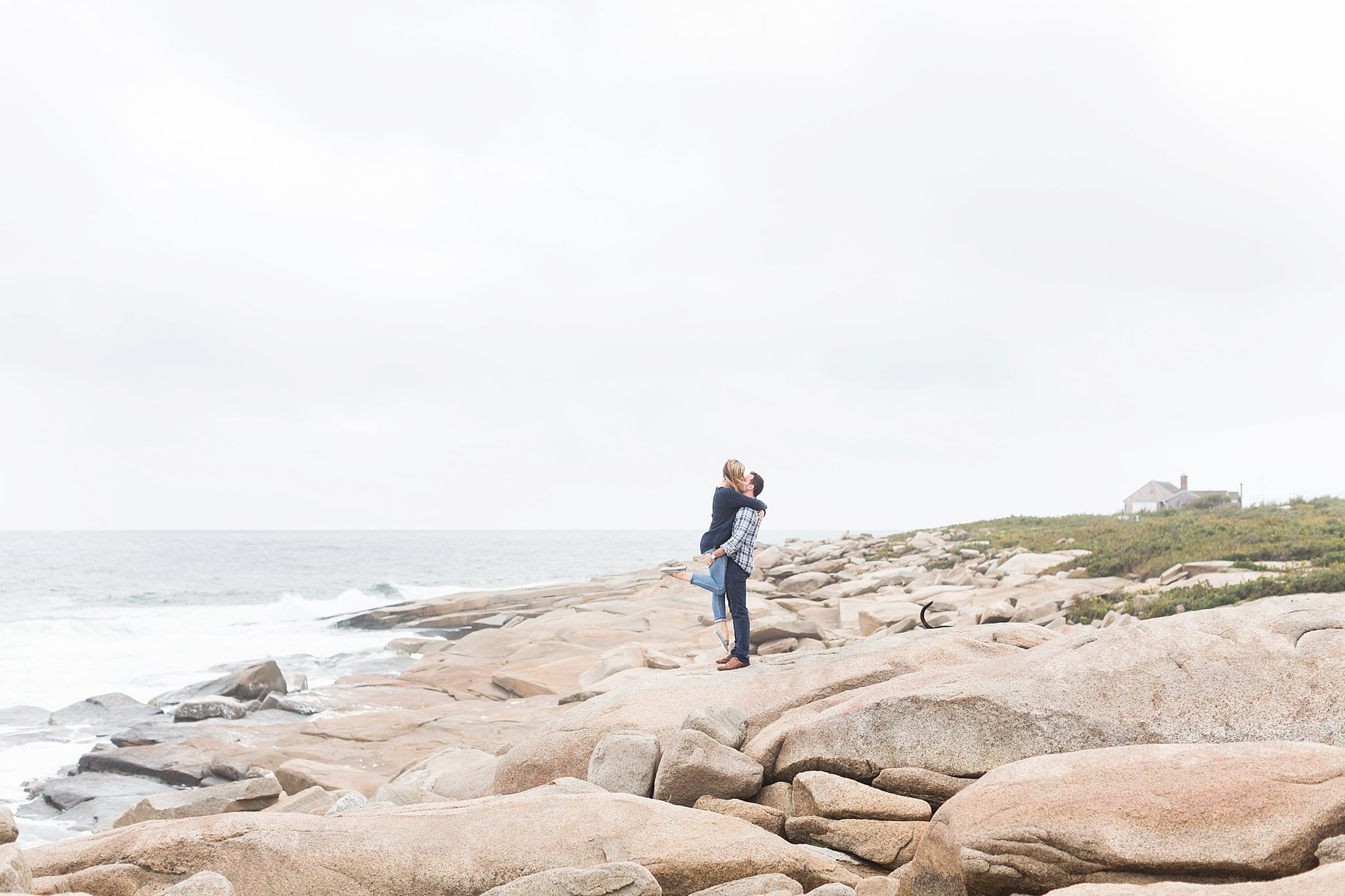 a man picking up a woman on the rocks at halibut point state park