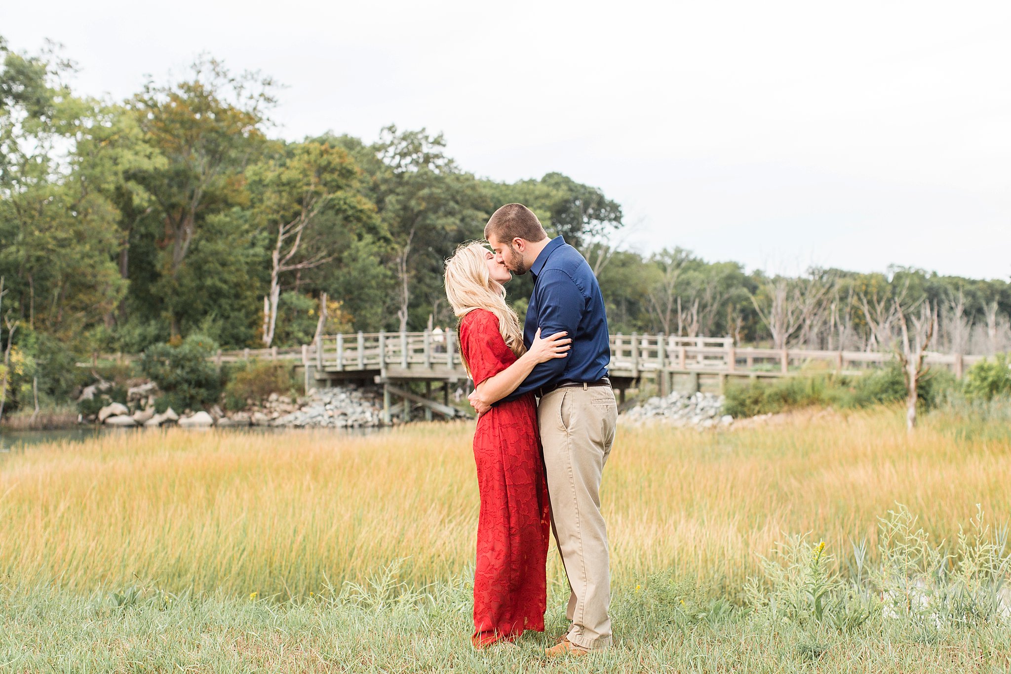 couple kissing in a field at World's End in Hingham, MA