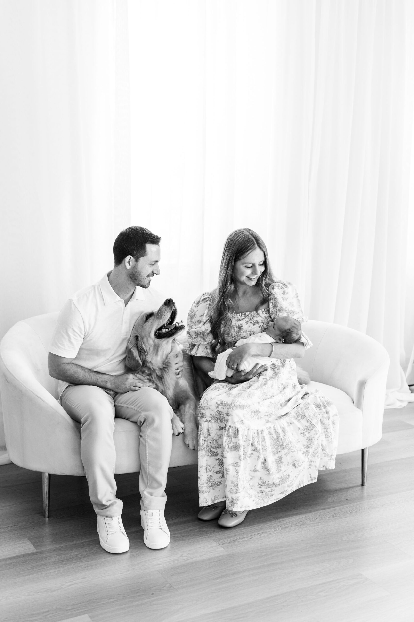 Black and white family photo with a dog in the studio