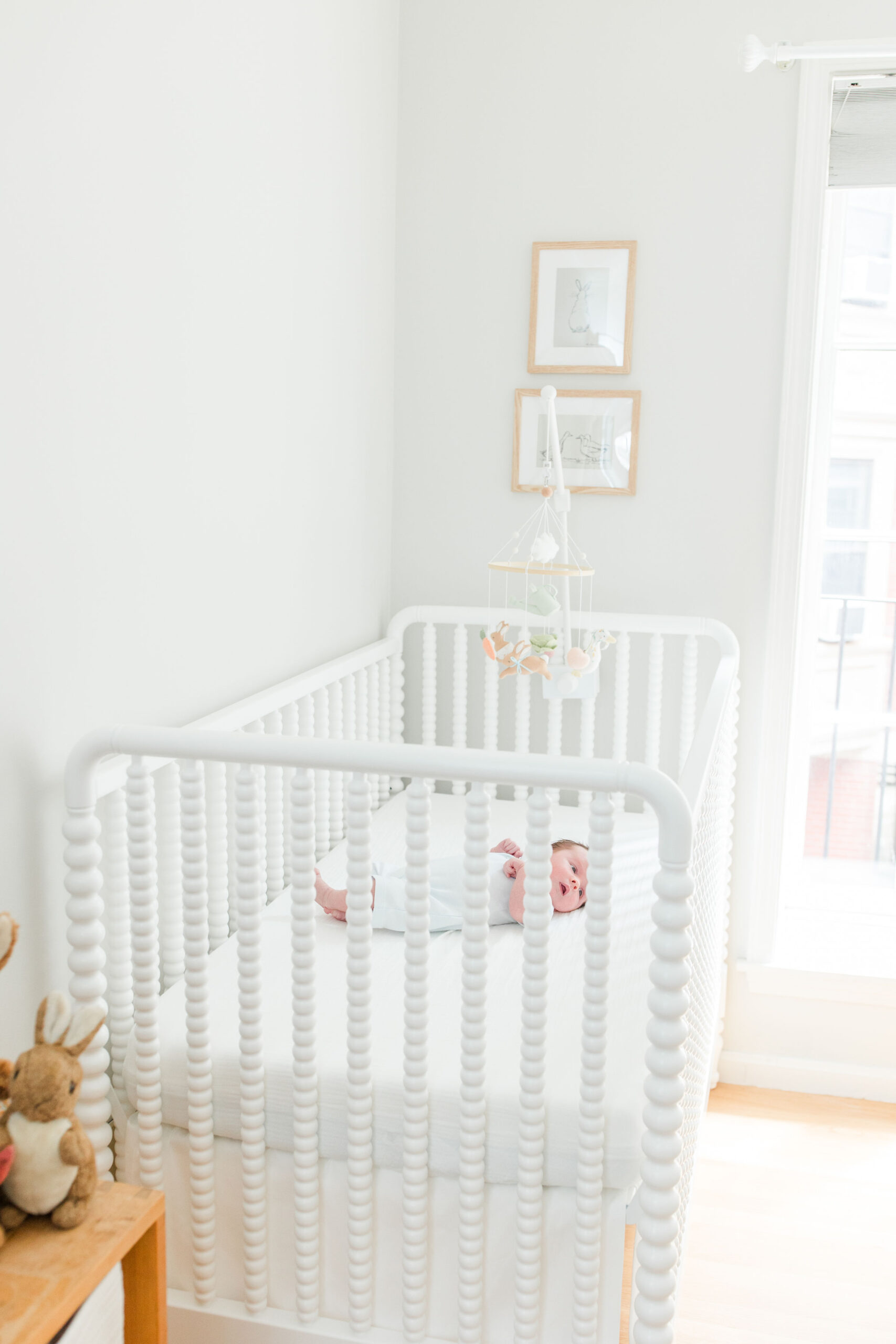 Baby laying in his crib in newborn photoshoot at home
