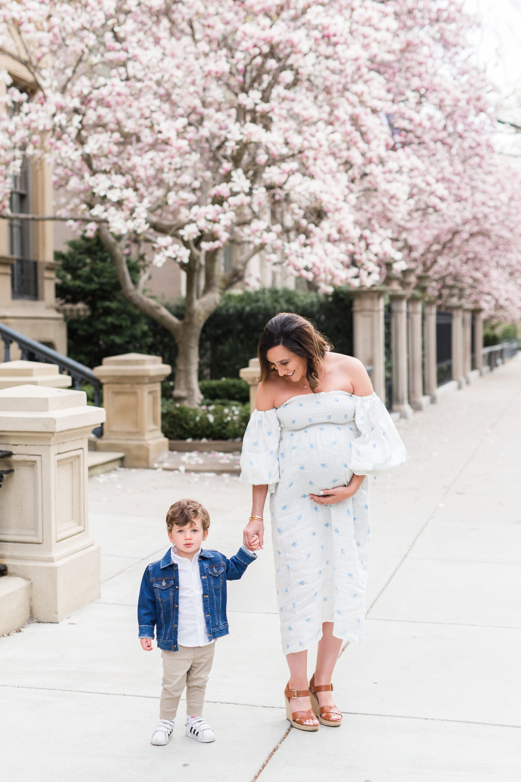 Mom walking holding her son's hand and her baby bump