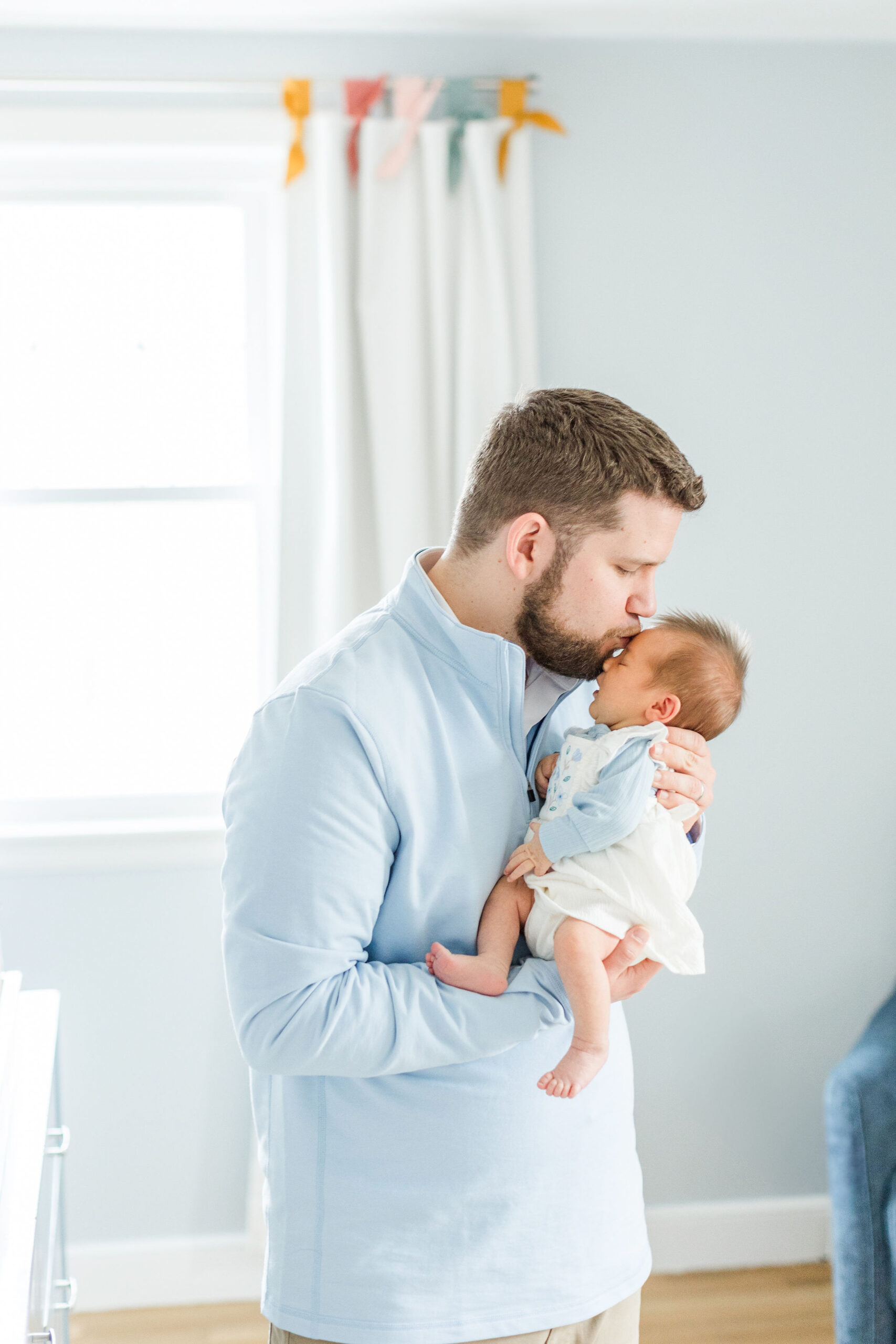 Dad kissing newborn baby on the forehead