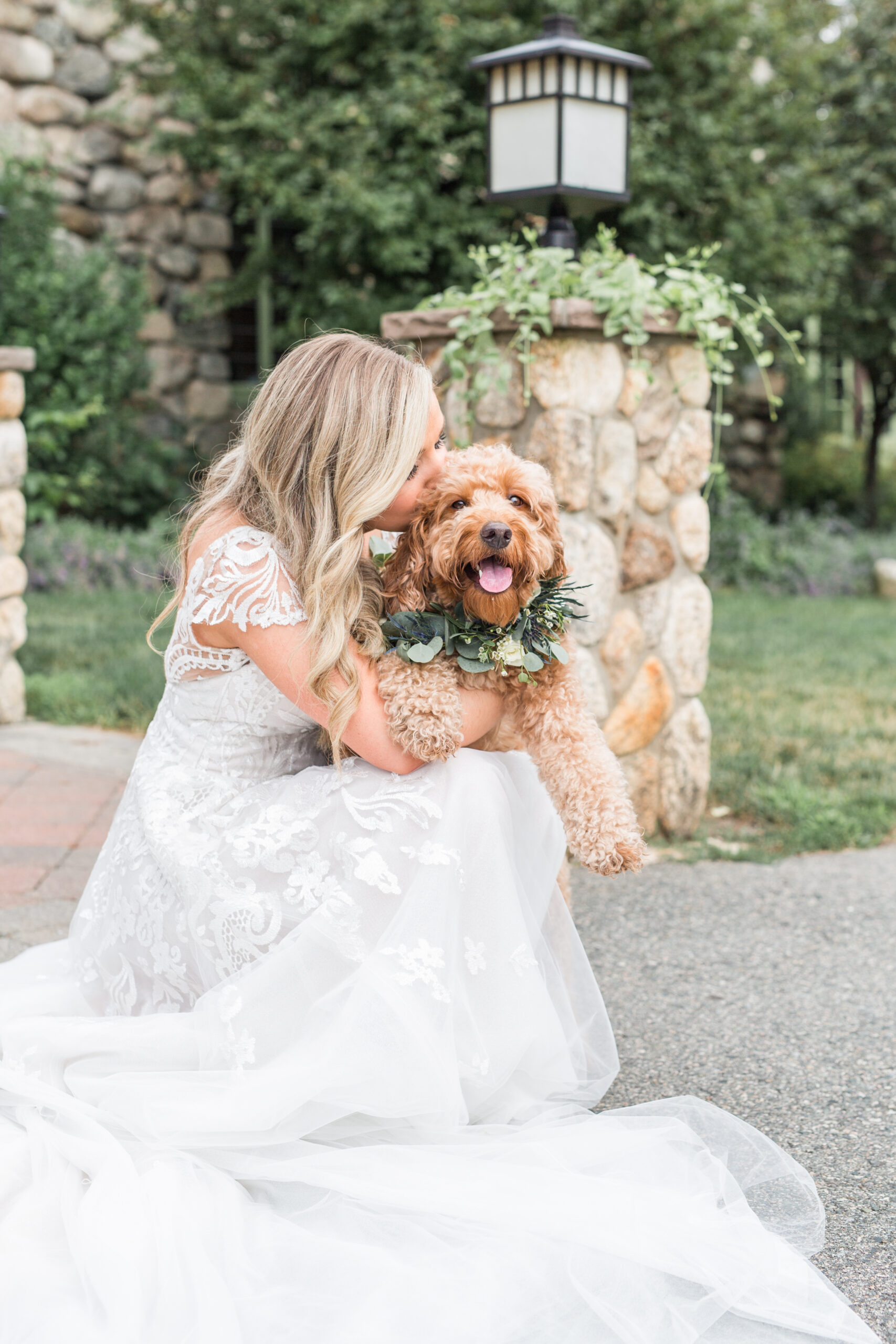 Bride kissing her dog in wedding photos