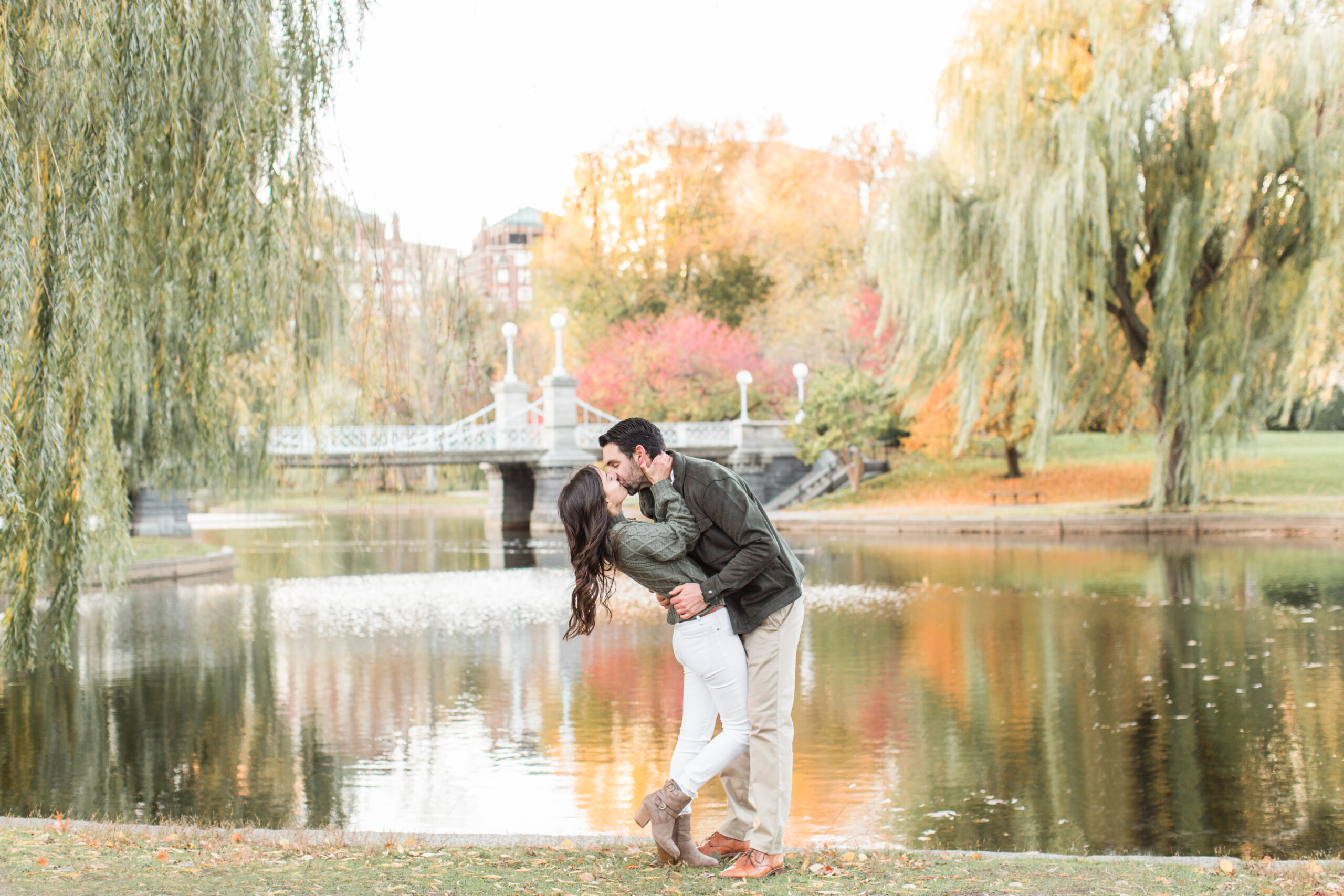 A couple kissing in front of the lake at Public Garden