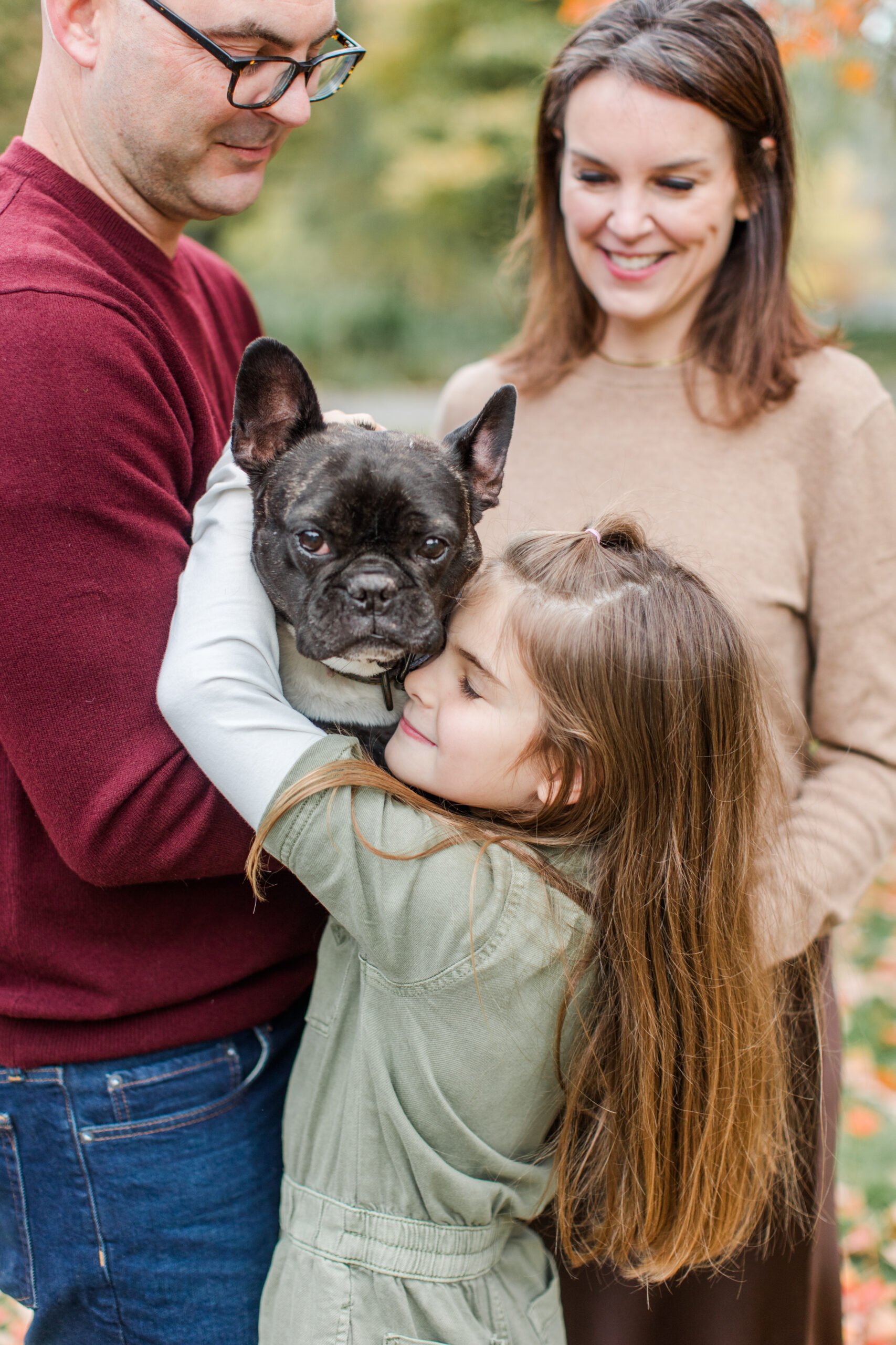 A girl hugging her dog during family photos