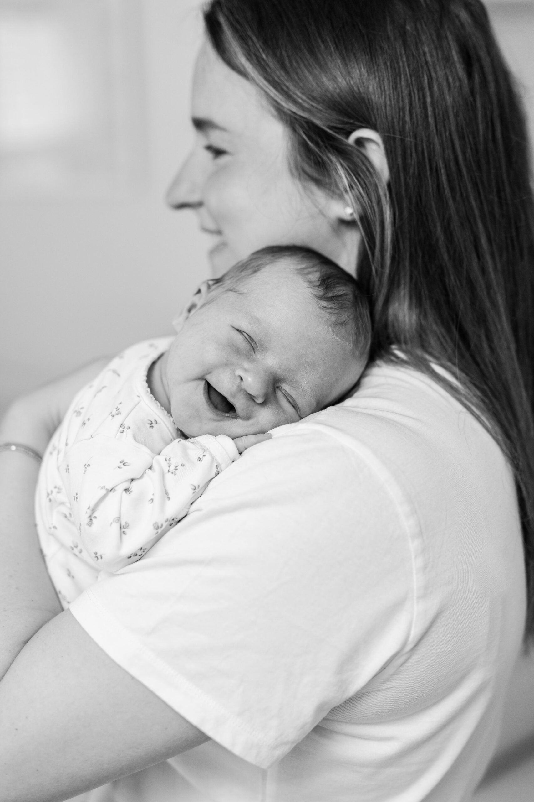 A newborn baby smiling during a newborn photoshoot
