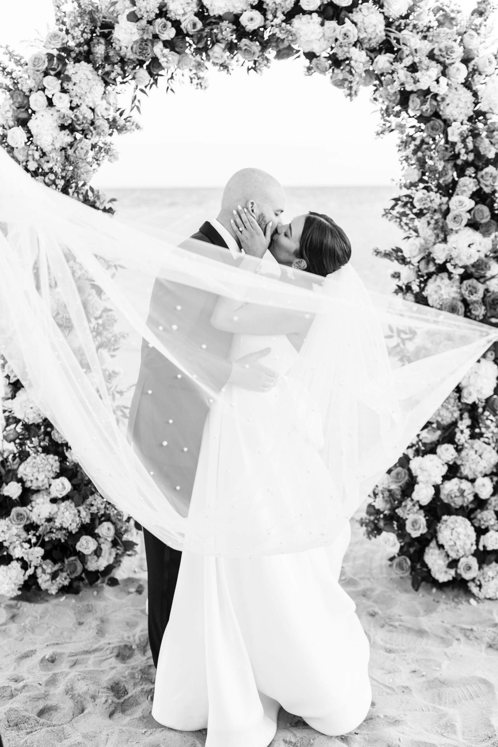 A black and white wedding photo of a beach wedding