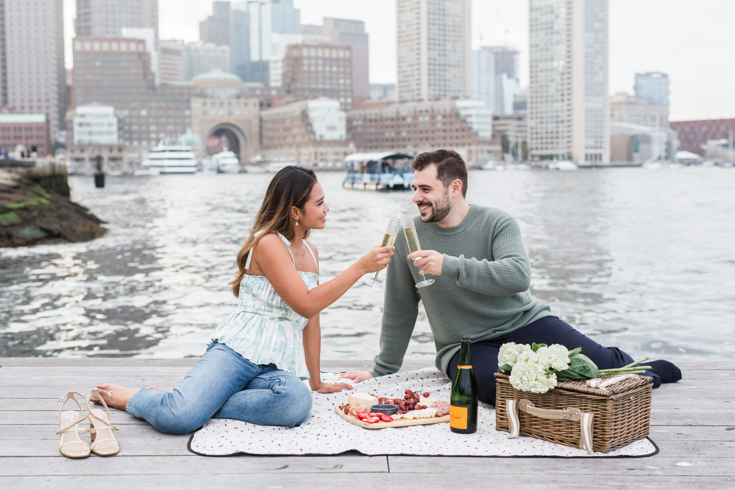 A couple having a picnic at Seaport for engagement photos