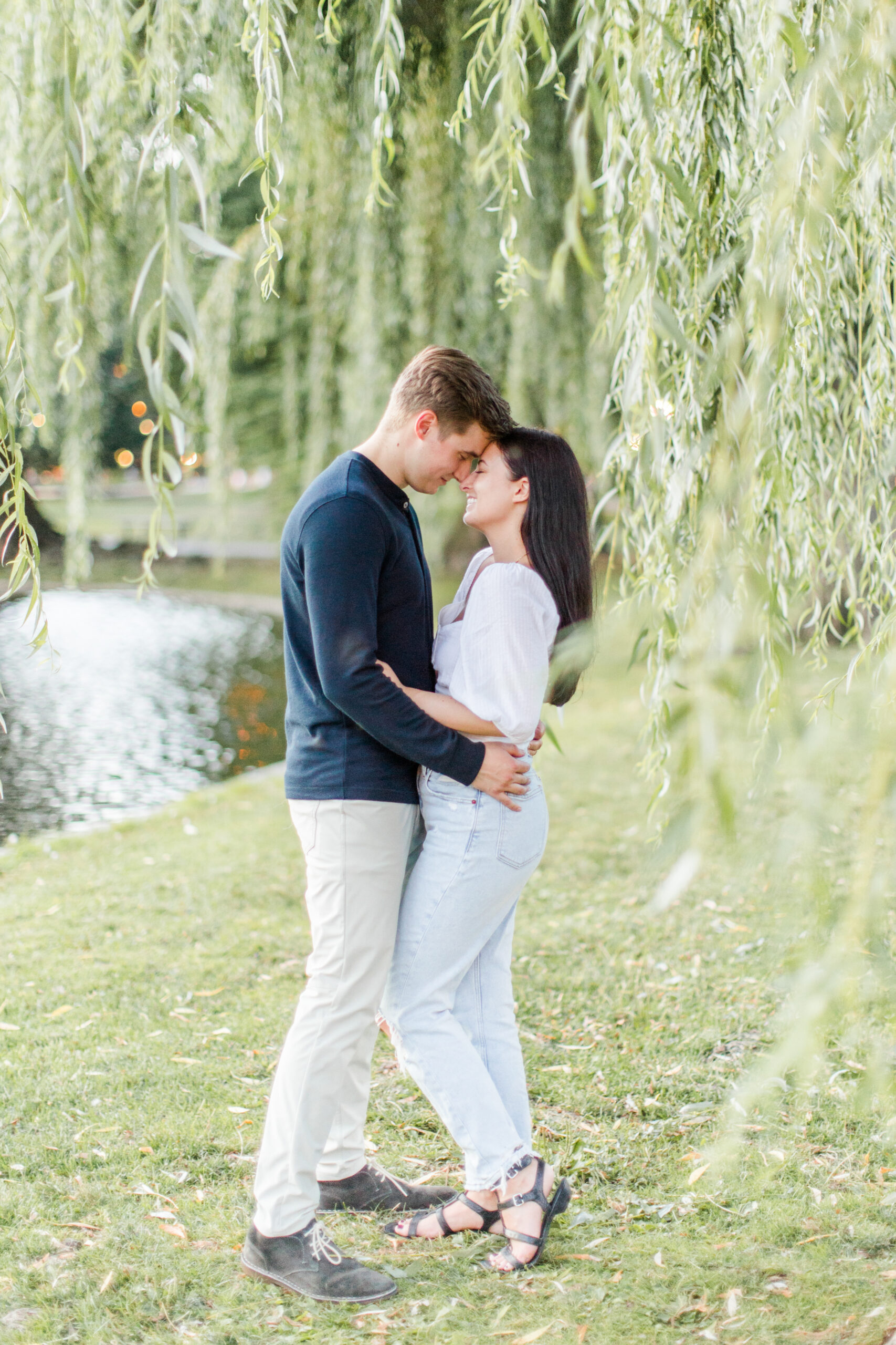 A couple kissing under a willow tree at Boston engagement photo location, Public GArden