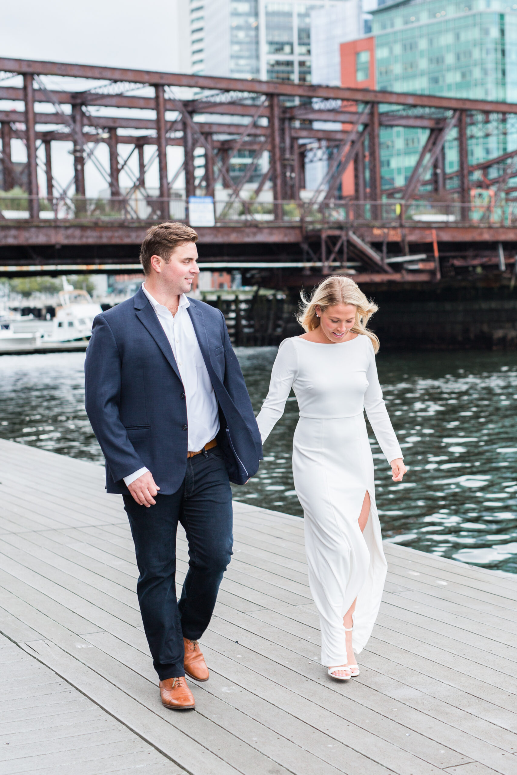 A couple walking on a riverwalk at one of my favorite boston engagement photo locations