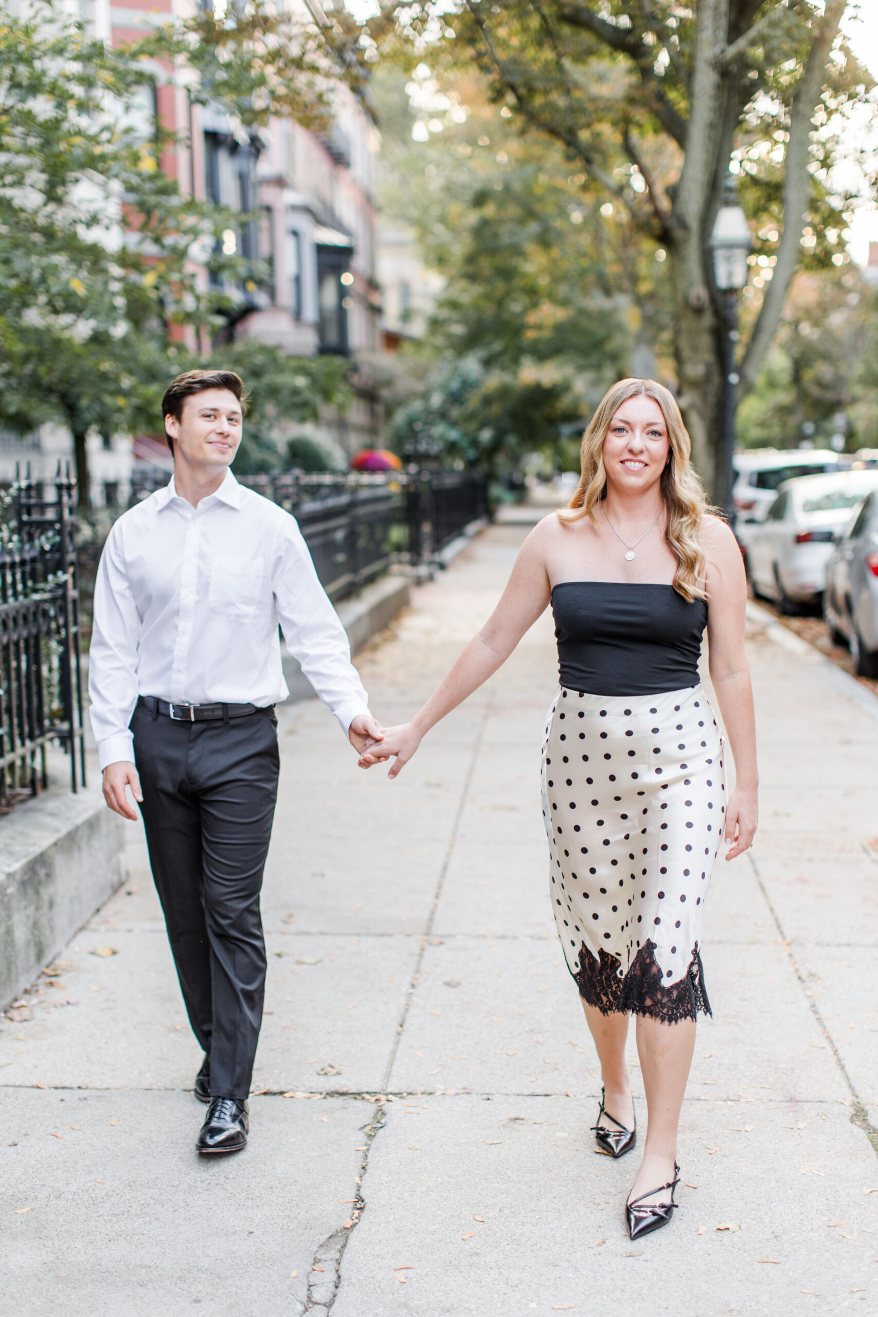 A couple walking for engagement photos at Boston engagement photo location, Beacon Hill