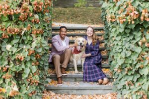 Man and woman sitting on stairs with a dog
