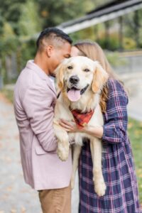 Man and woman hold large dog during Boston family photos