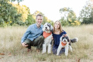 Man and woman crouched down with two dogs