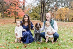 Man and woman with two small children and their brown dog