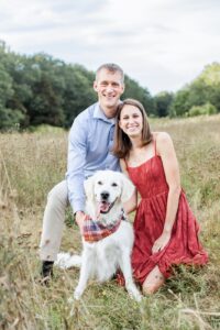 Man and woman pose in field with cream dog during Boston family photos