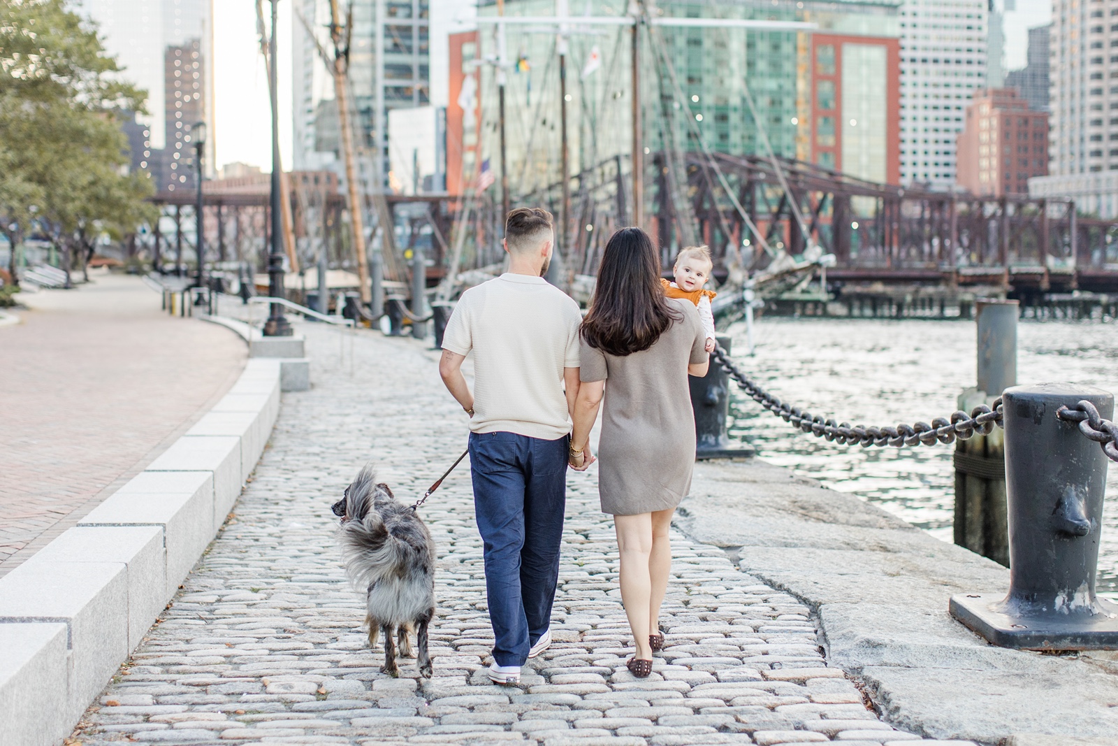 Man and woman walking with dog during Boston family photos with dogs