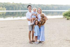Man and woman hold baby and have toddler and dog during Boston family photos with dogs