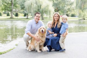 Family crouched down with their dog during Boston family photos with dogs