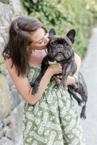 Woman kisses small dog during Boston family photos with dogs